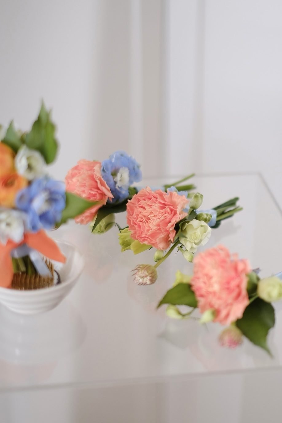 Summer dramatic · cascading bridal bouquet in tangerine, dusty blue, ivory, crimson and blush — close-up