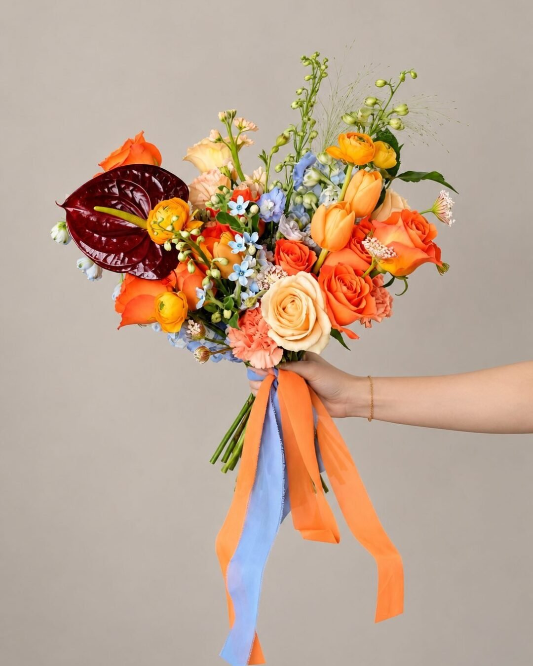 Summer dramatic · cascading bridal bouquet in tangerine, dusty blue, ivory, crimson and blush