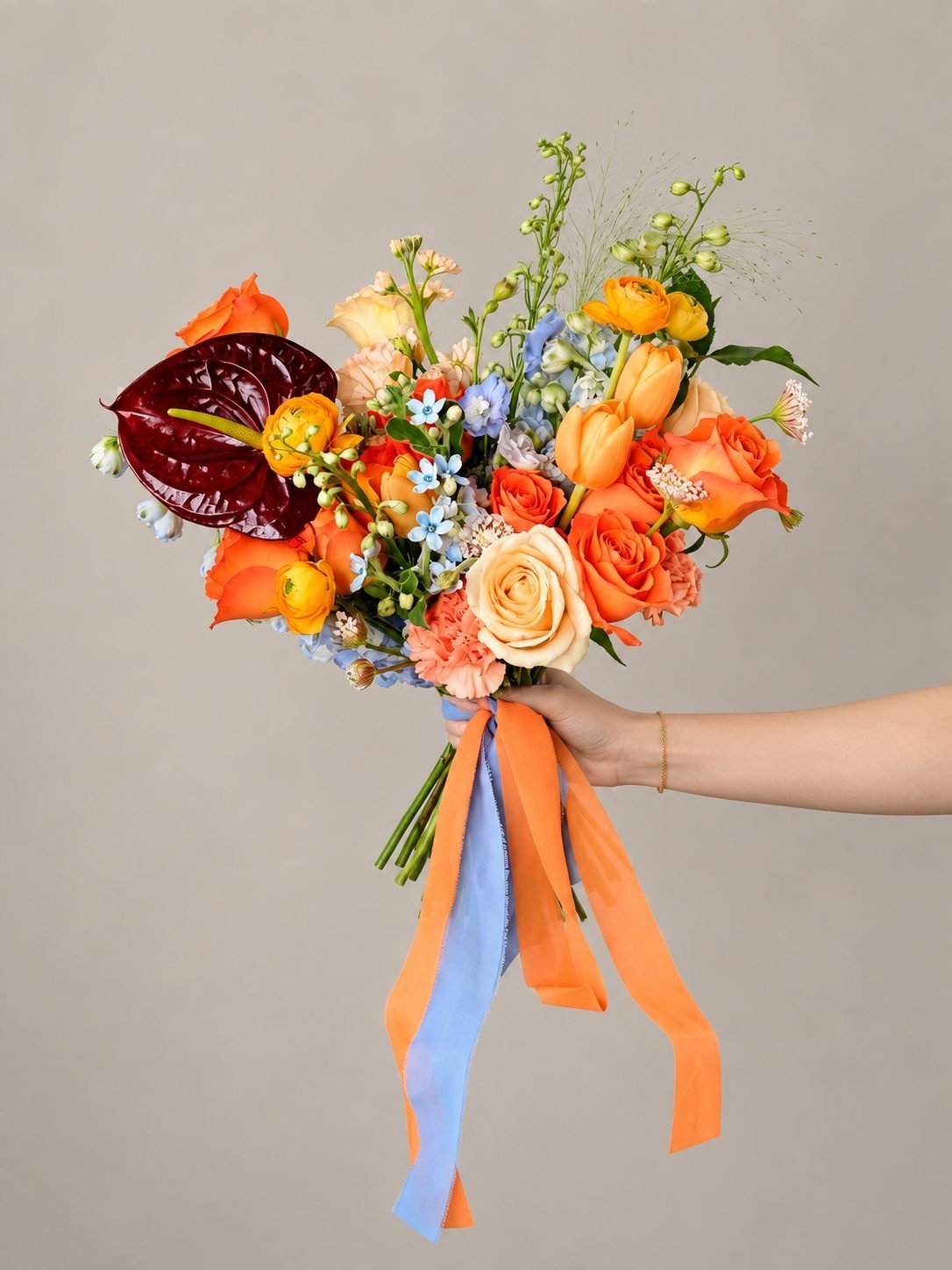 Summer dramatic · cascading bridal bouquet in tangerine, dusty blue, ivory, crimson and blush