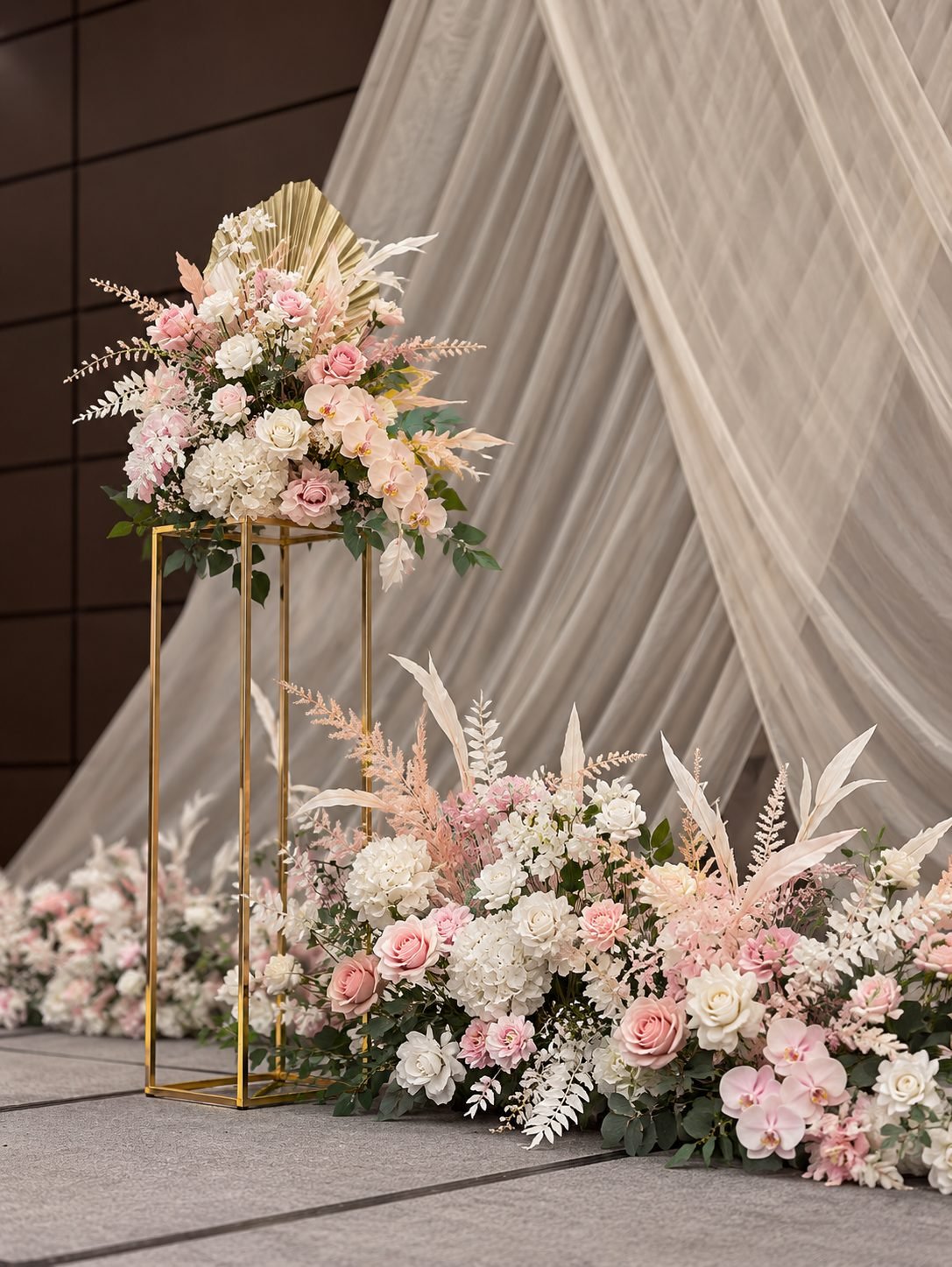 Close-up of a gold-frame pedestal arrangement in blush and white with a floor floral mound