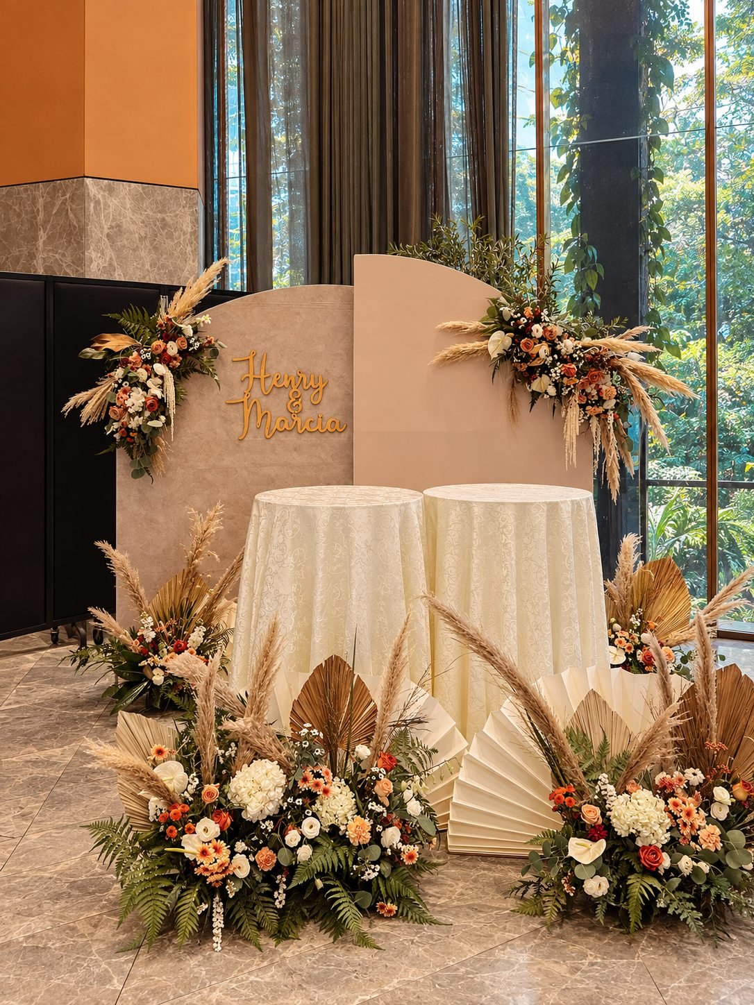 Warm welcome backdrop dressed with terracotta, ivory and pampas florals beside two guestbook tables