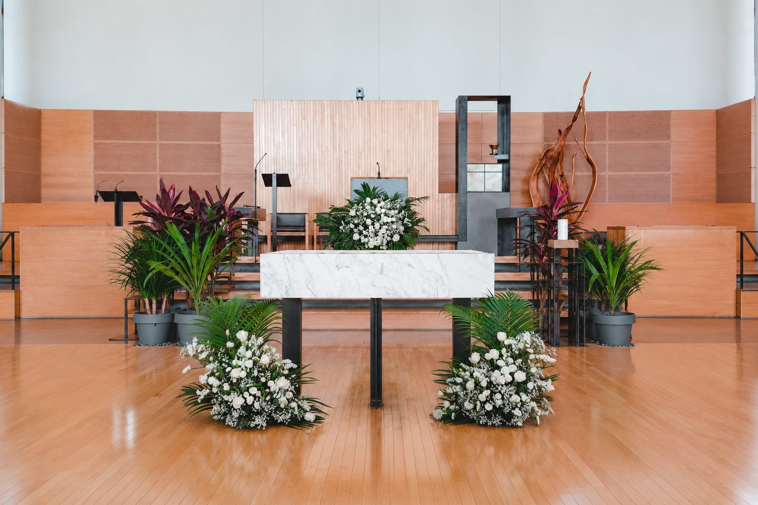 White flowers and greenery framing a modern church altar