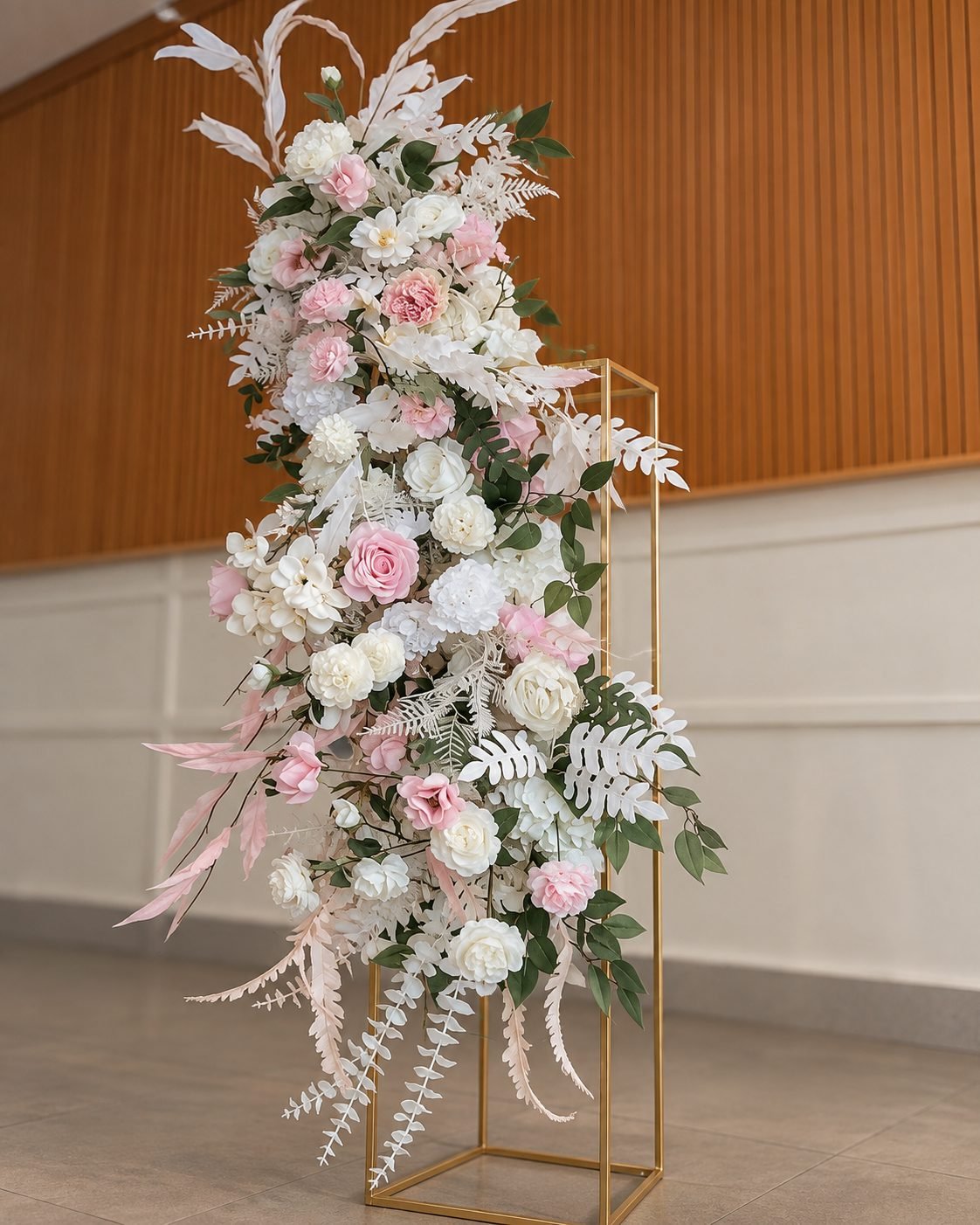 Tall cascading blush and white arrangement on a gold frame, detailed view